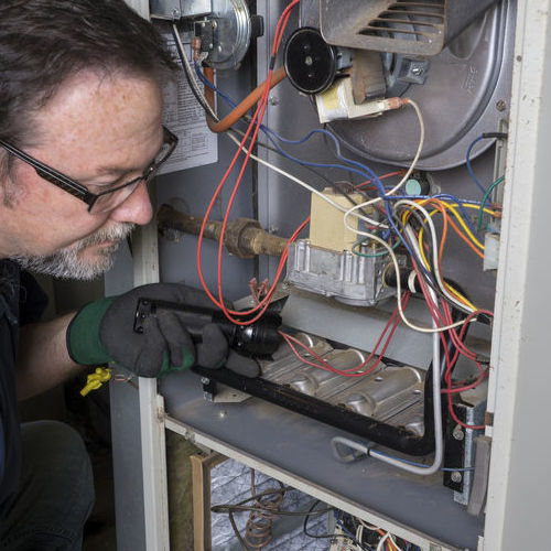 A Technician Checks a Gas Furnace.